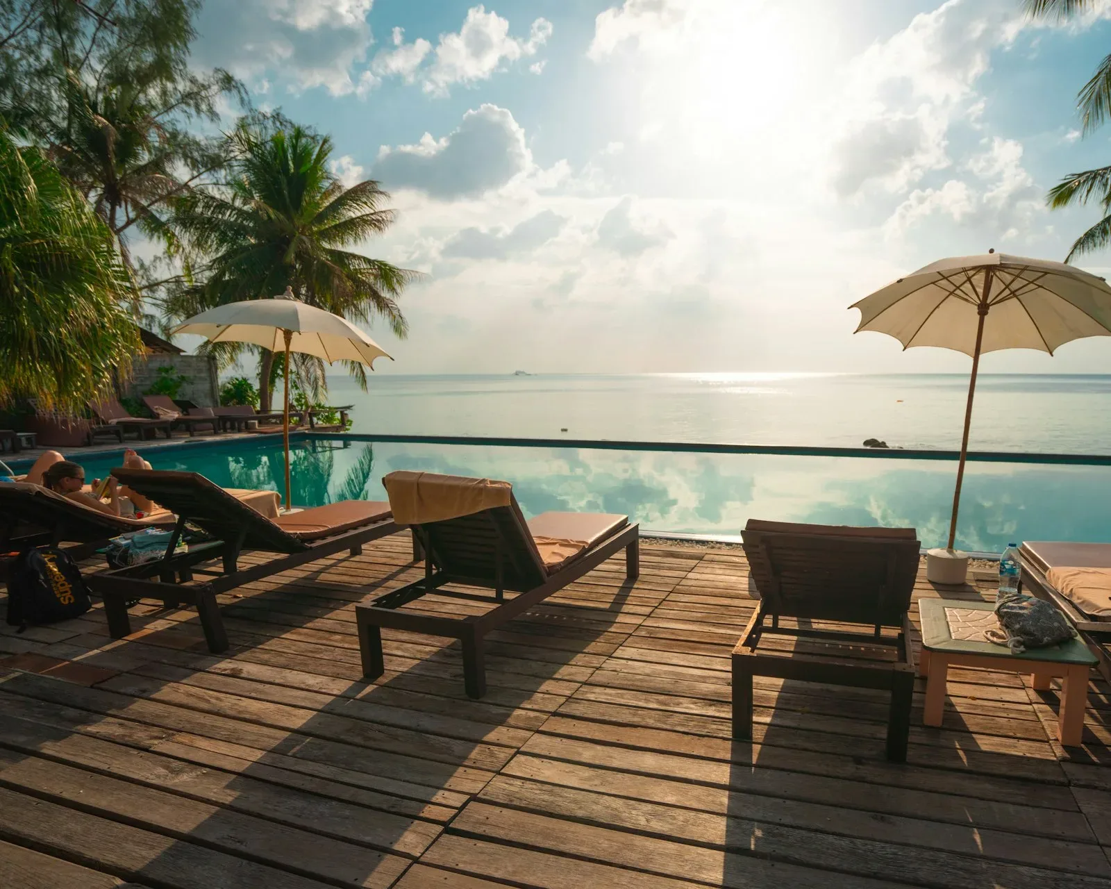 Sun loungers and a parasol on a guesthouse pool deck
